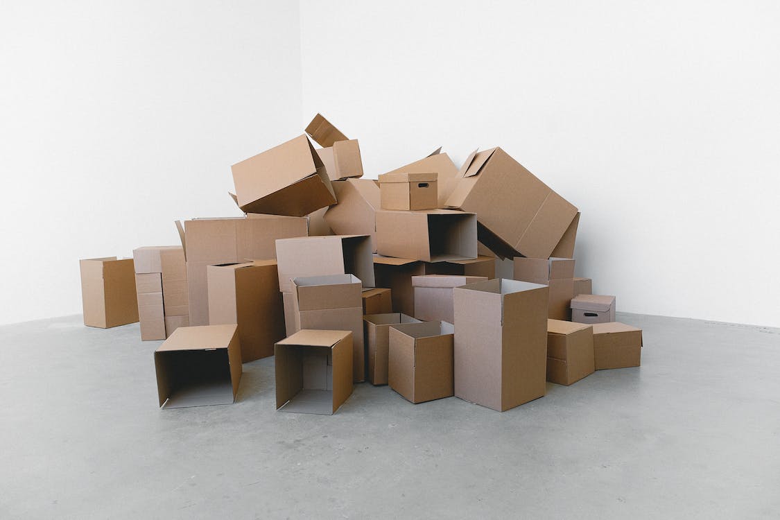 Free Stack of carton boxes on floor in rented house Stock Photo
