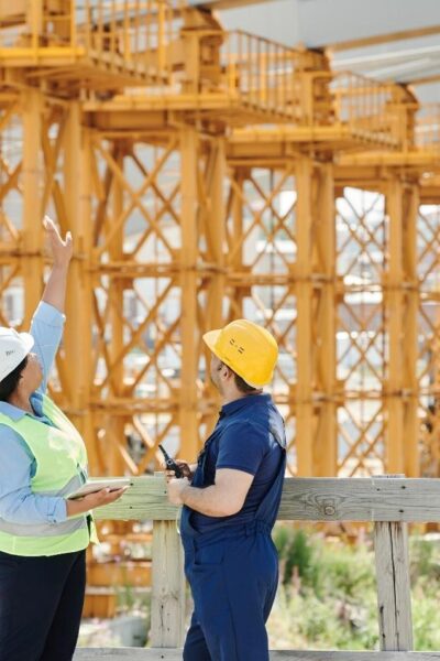 A Man and a Woman with Ppe's Talking at a Construction Site